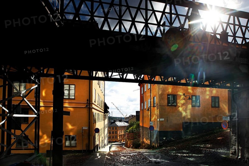 Bright buildings in Södermalm, Stockholm, in sunlight under a bridge, Stockholm, Södermanland, Sweden