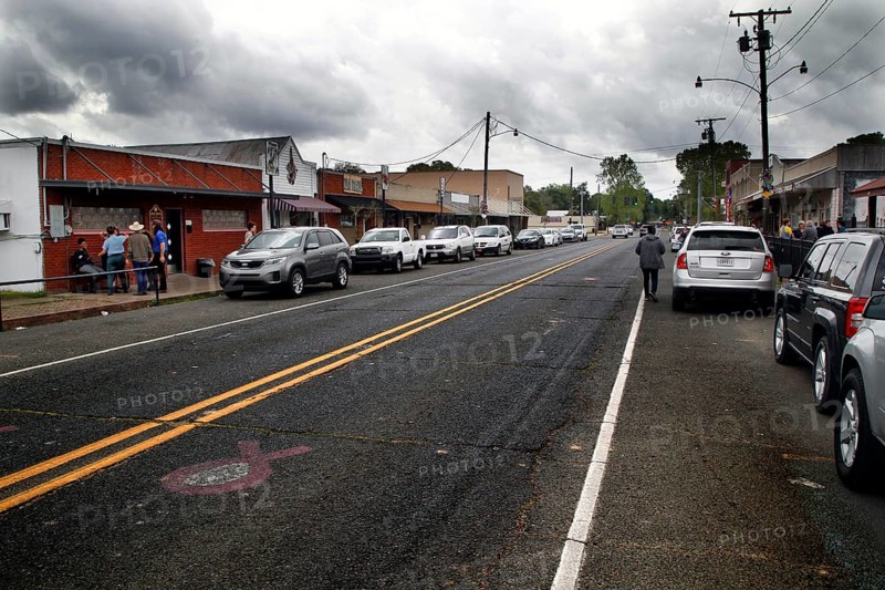 Busy main street with shops and parked cars in Mamou, Mamou, Louisiana, USA