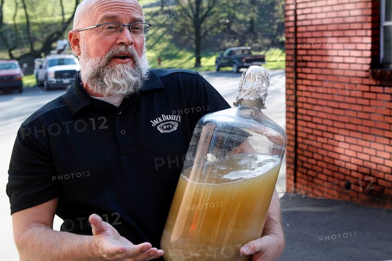 An employee from Jack Daniel's Distillery shows a large glass container, Lynchburg, Tennessee, USA