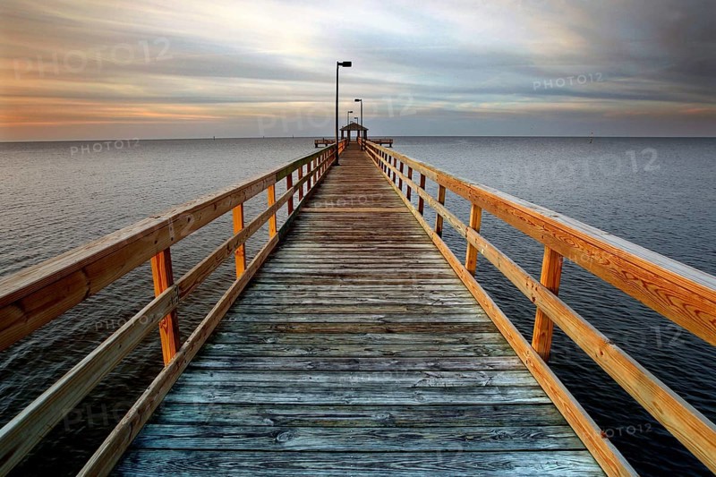A long wooden pier stretches out into the calm sea at sunset in Biloxi, Biloxi, Mississippi, USA