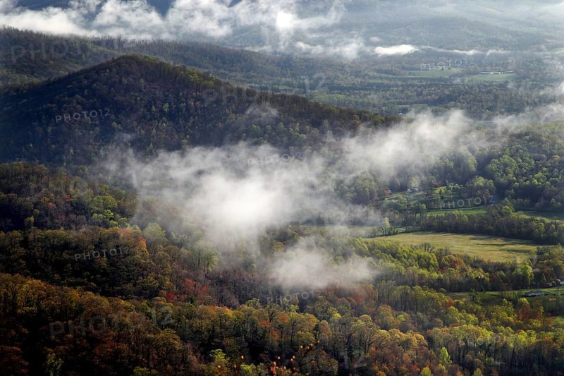 Fog sweeps through wooded hills and valleys