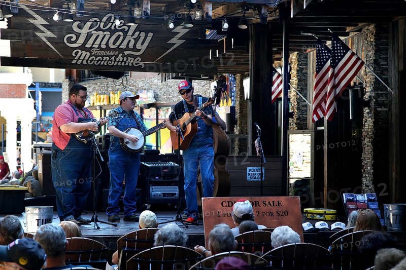 Musicians on an outdoor stage with Ole Smoky in Gatlinburg, with banjo and guitars, Gatlinburg, Tennessee, USA