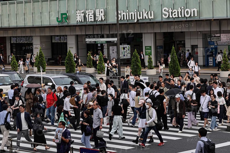 Passers-by cross the street in front of Shinjuku Station in Tokyo, Tokyo, Shinjuku, Japan