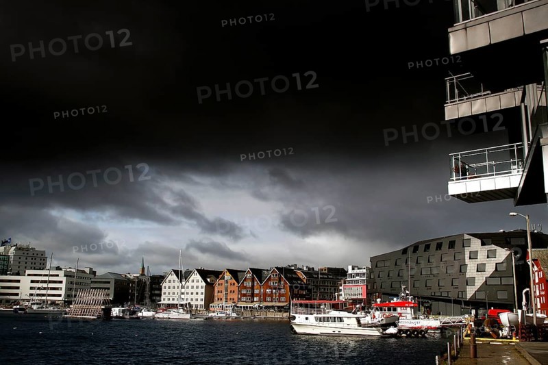 Wooden houses and water in central Tromsø under dark sky, Tromsø, Troms, Norway