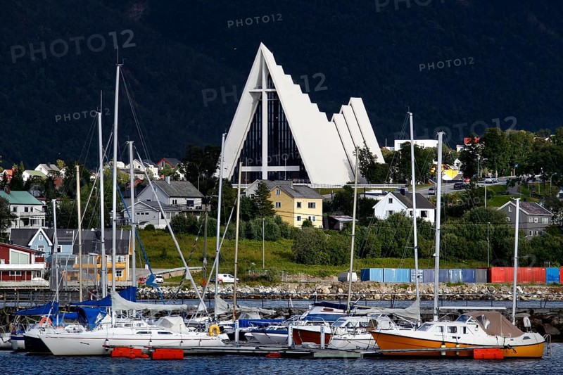 Ishavskatedralen towers over boats and houses in Tromsdalen, Tromsø, Troms, Norway