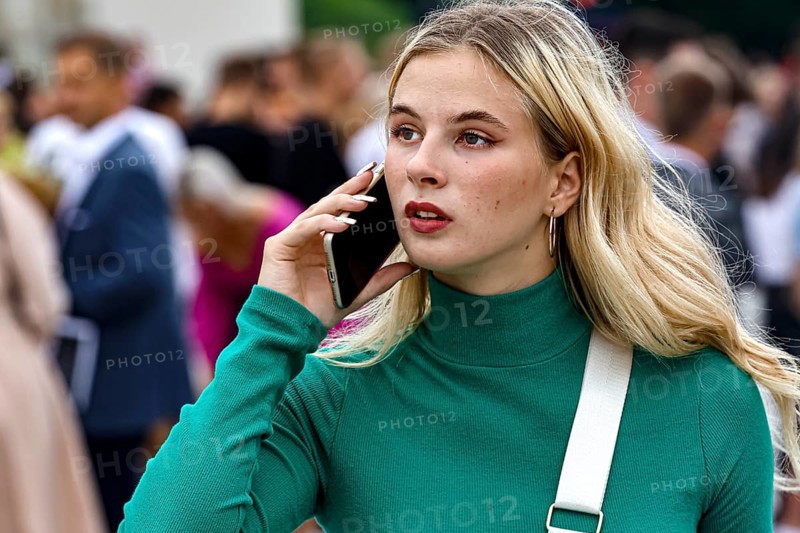 Young woman talking on the phone during a high school graduation ceremony on Cathedral Square, Vilnius, Vilnius County, Lithuania