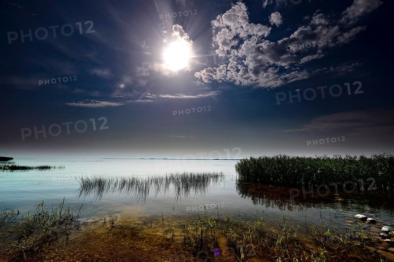 Brilliant full moon over the quiet Curonian Lagoon at night in Vente, Vente, Lithuania