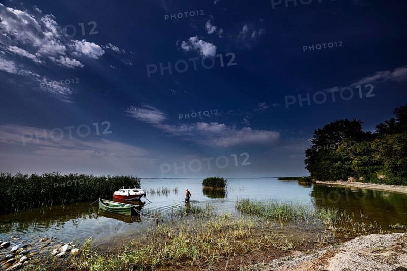 Boats on calm water with wide skies in the Curonian Lagoon near Vente, Vente, Lithuania