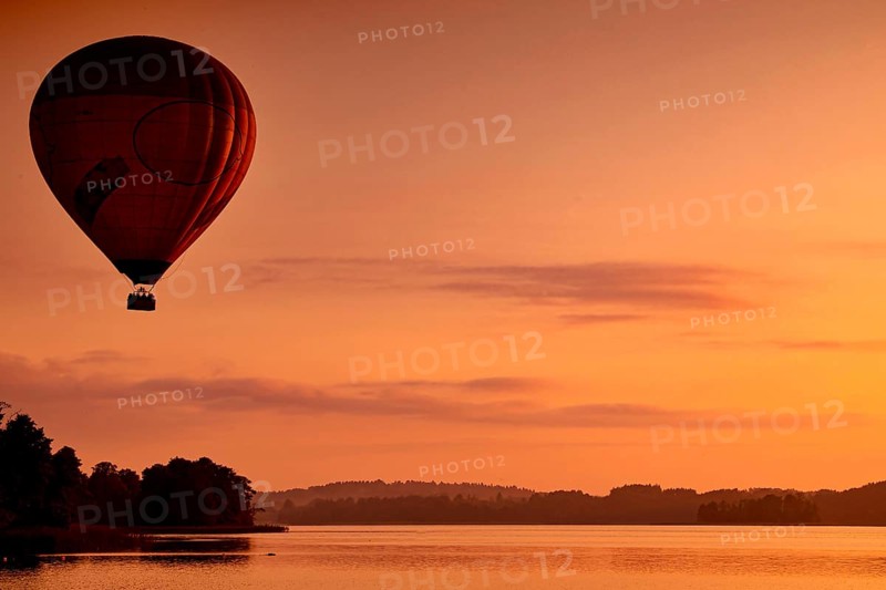 Hot air balloon at dusk over a still lake, Trakai, Vilniaus Apskritis, Lithuania