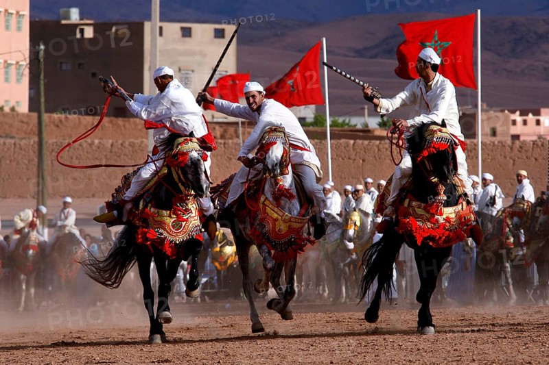 Riders in traditional clothing perform at Fantasia during the Fête des Roses, El Kelâa m'Gouna, Morocco