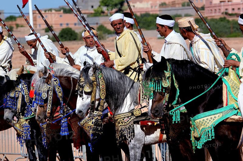 Rider on horseback, magnificently decorated with traditional accessories, parading in the arid countryside, El Kelâa m'Gouna, Morocco