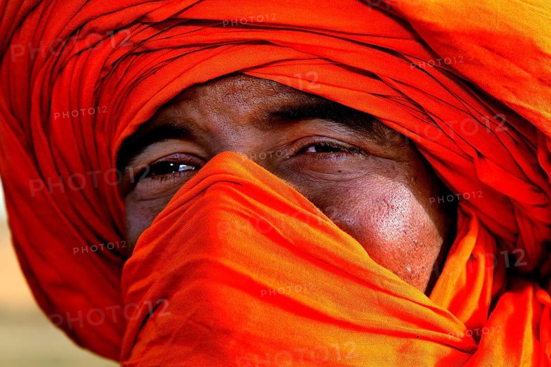 Portrait of a Bedouin wearing a bright orange turban in the Erg Chebbi Desert, Erg Chebbi, Morocco