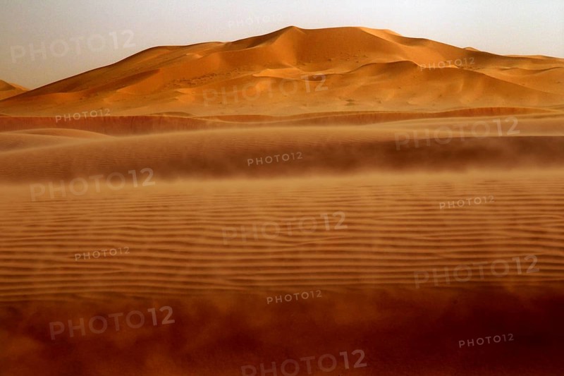 Dust envelops the sand dunes in the sprawling Erg Chebbi, Erg Chebbi, Morocco