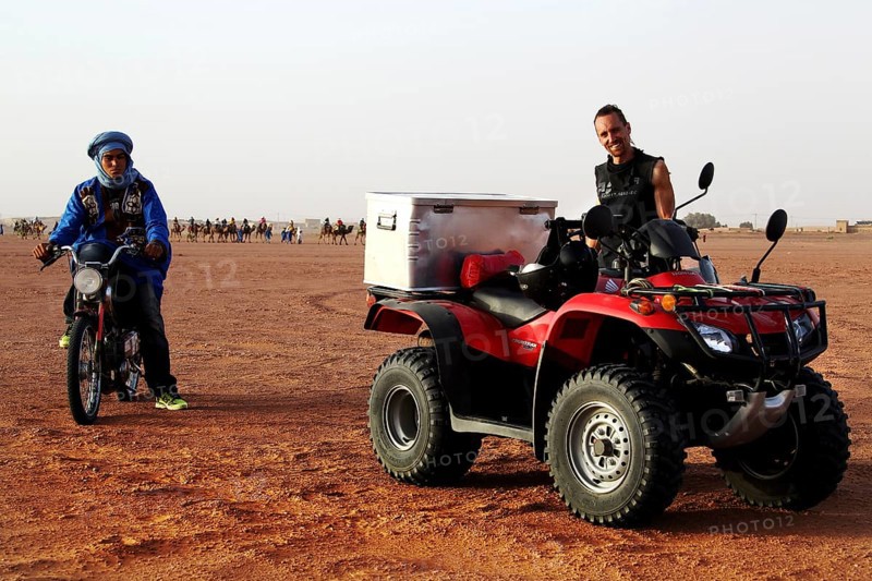 A quad bike and a motorcycle stand side by side in the desert landscape, Erg Chebbi, Morocco