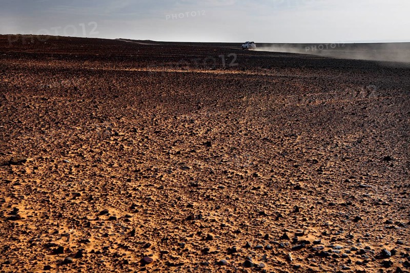 Endless expanse of dusty desert landscape under clear skies, Erg Chebbi, Morocco