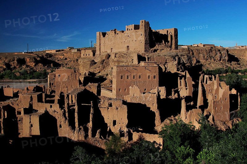 Clay kasbahs in a majestic desert backdrop under clear blue sky, El Kelâa m'Gouna, Valley of Roses, Morocco