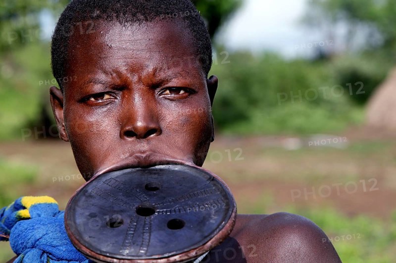 Portrait of a Mursi woman with lip plate and distinctive facial expression in Mago National Park, Mago National Park, Ethiopia