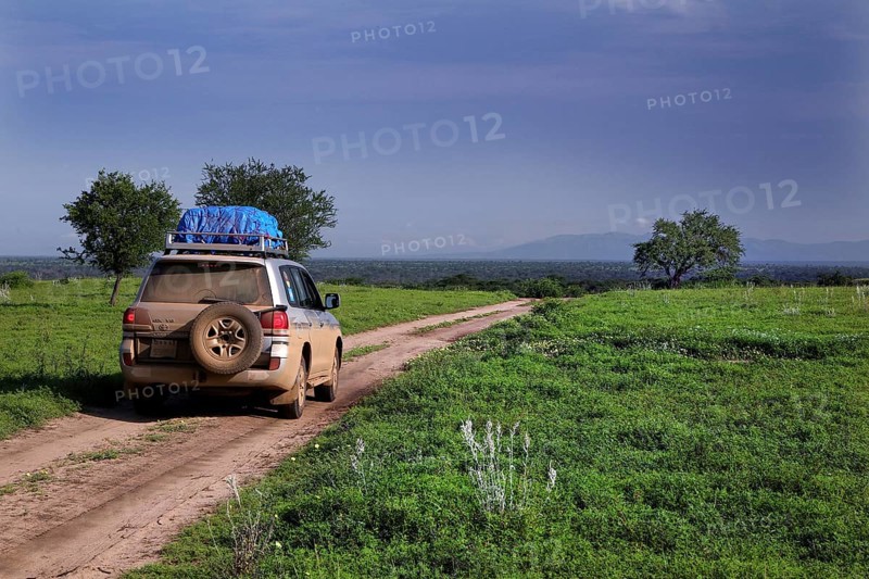 A land cruiser rides on a track through the tree savanna, Murle, Ethiopia