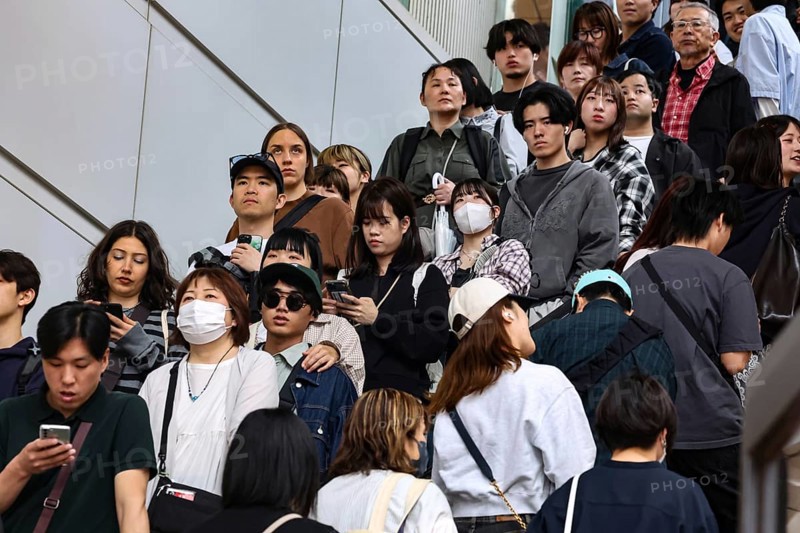 People on an escalator in Shibuya Station, partly wearing face masks, Tokyo, Japan