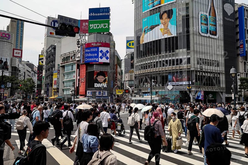 People cross the well-known Shibuya intersection surrounded by billboards, Tokyo, Japan
