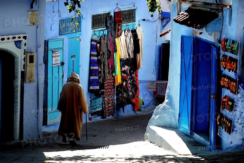 Winding alleys of the Medina with blue walls and colorful clothes, Chefchaouen, Morocco