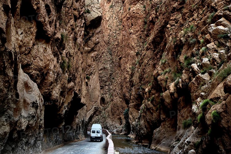A white vehicle drives through the narrow section of Dadès Gorge, Dadès Gorge, Morocco