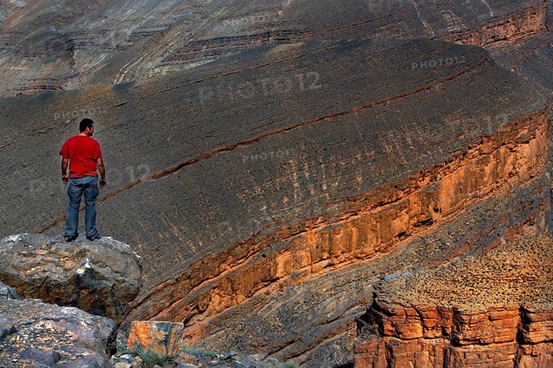 Man standing on rocks and looking at the impressive Dadès Gorge, Dadès, Morocco