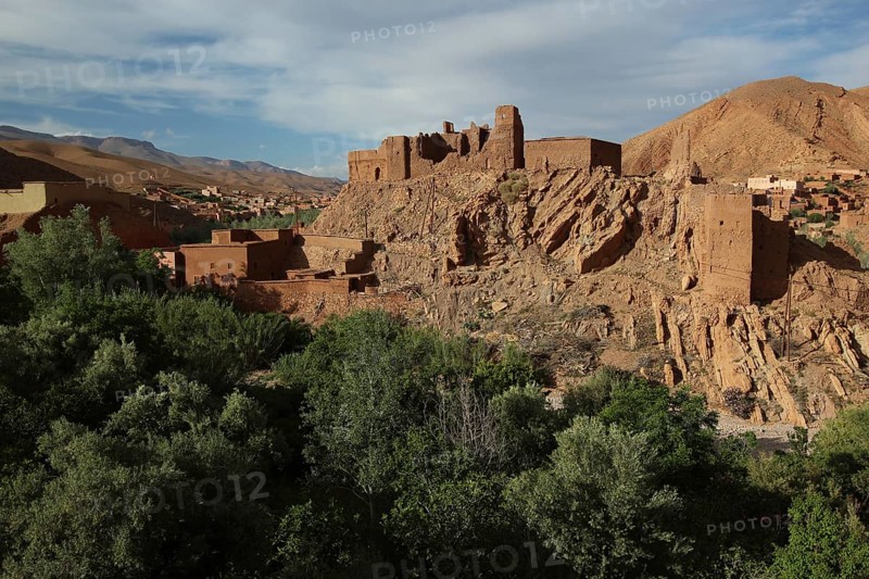 Historic rock structures in Dadès Canyon surrounded by green trees, Dadès Gorge, Morocco