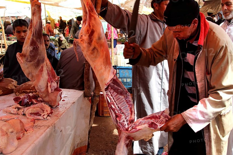 Butchers at a market in Achaouikh processing meat in a lively atmosphere, zero