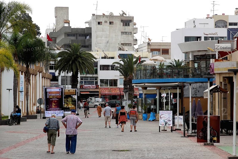 Passers-by stroll through Agadir's pedestrian zone under palm trees, Agadir, Souss, Morocco