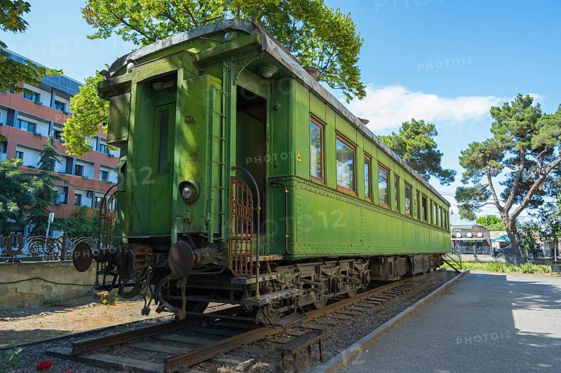 Green historic train car on rails between trees in an urban environment, Stalin's personal railroad car, Gori, Inner Kartli region, Georgia