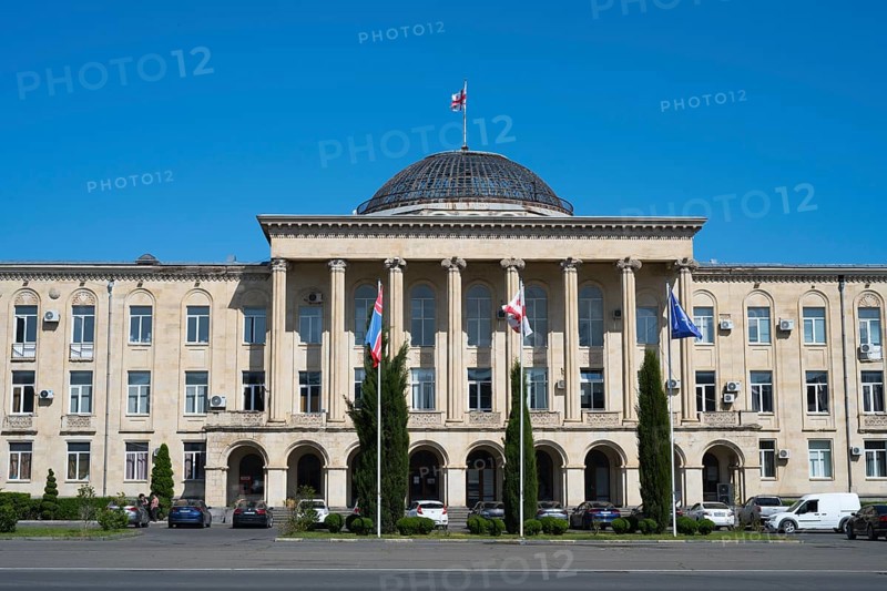 View of classic building with dome and flags surrounded by cypresses, City Hall, Gori, Inner Kartli region, Georgia