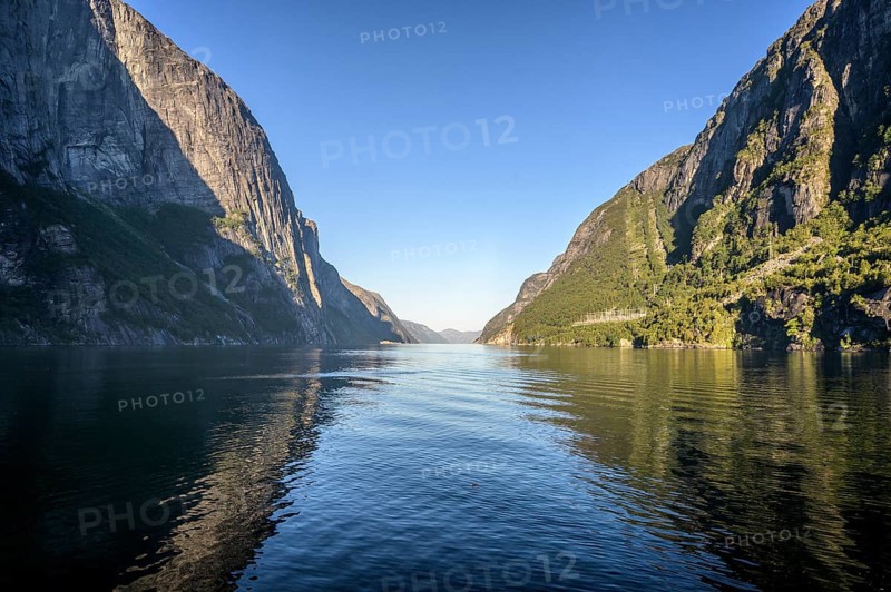 Tranquil Lysefjord surrounded by high mountains whose reflections are visible in the water