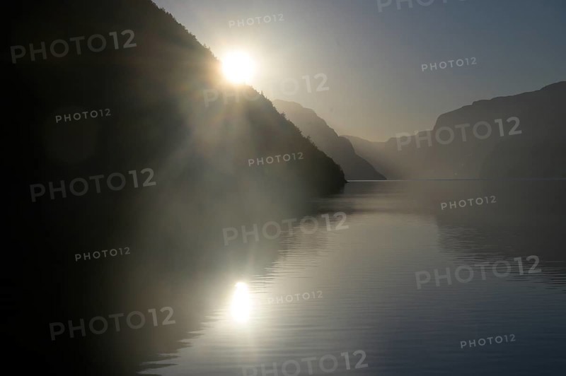 Foggy morning atmosphere over the quiet Lysefjord at sunrise between mountains