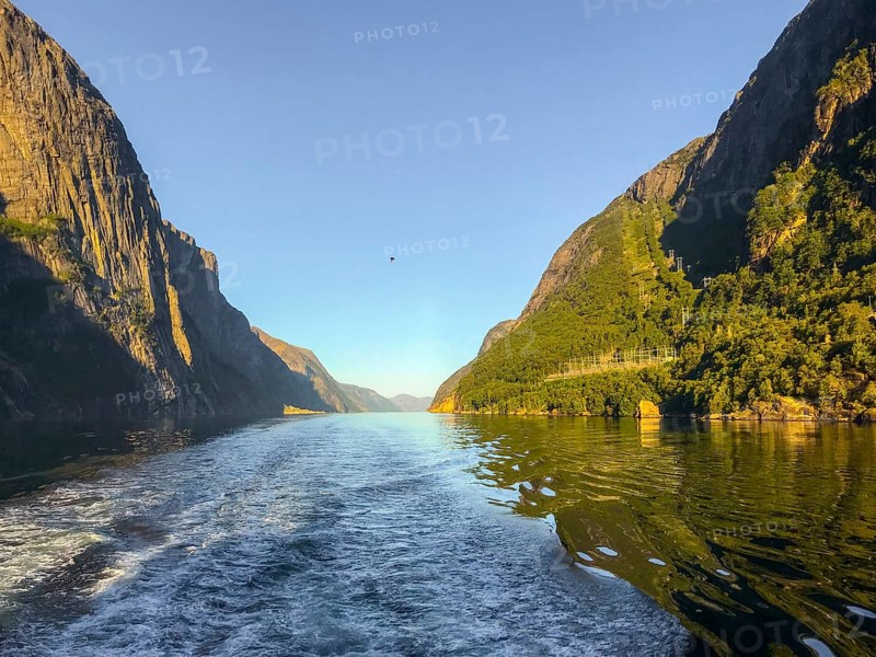 Lysebotn, Rogaland Municipality, Norway, Lysejord with calm water surrounded by steep, sunlit mountain slopes