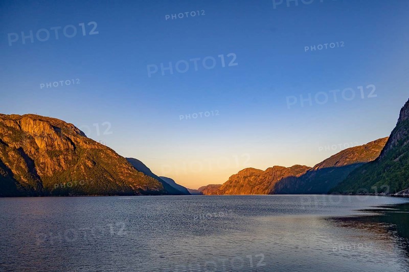 View of Lysefjord and illuminated mountains in the warm light of dusk, Lysefjord, Rogaland, Norway