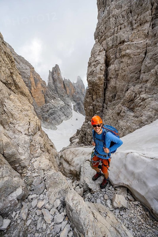 Mountaineers on the Bocca d'Ambiez, Via Ferrata dell'Ideale via Ferrata dell'Ideale, spectacular mountain landscape with steep rock faces, remains of the Vedretta d'Ambiez glacier in the back, Brenta Mountains, Brenta-Adamello Nature Park, Trentino, Italy
