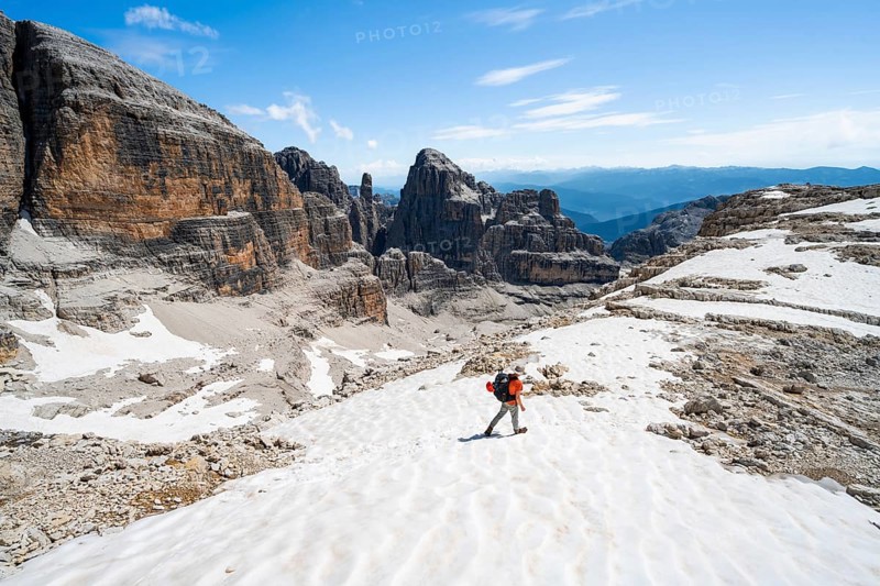 Mountaineers in a snowfield on the Sella della Tosa, mountain landscape with steep cliffs, Brenta Mountains, Brenta-Adamello Natural Park, Trentino, Italy