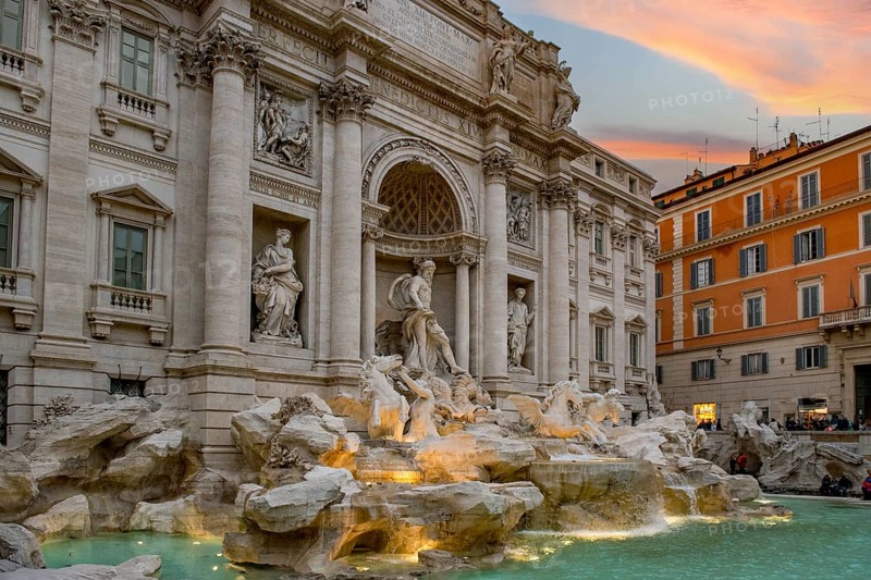 View at dusk at dusk with dramatic light in the sky of the partially illuminated Fontana di Trevi fountain in the old town of Rome, Rome, Lazio, Italy