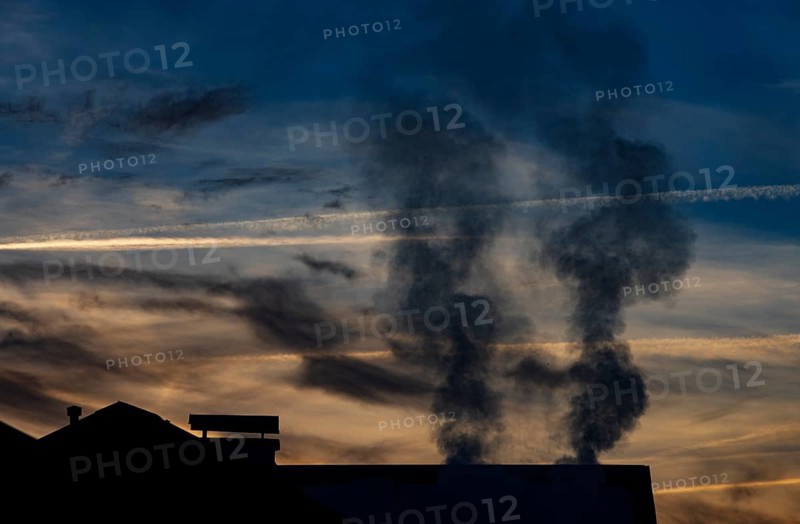 Smoking chimney of a residential building in winter, sunset, environmental pollution, Mondseeland, Salzkammergut, Upper Austria, Austria