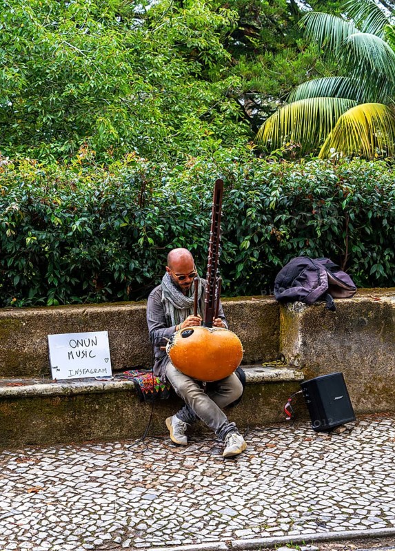 Musician sitting on the side of the N375 road in Sintra, Lisbon, Portugal