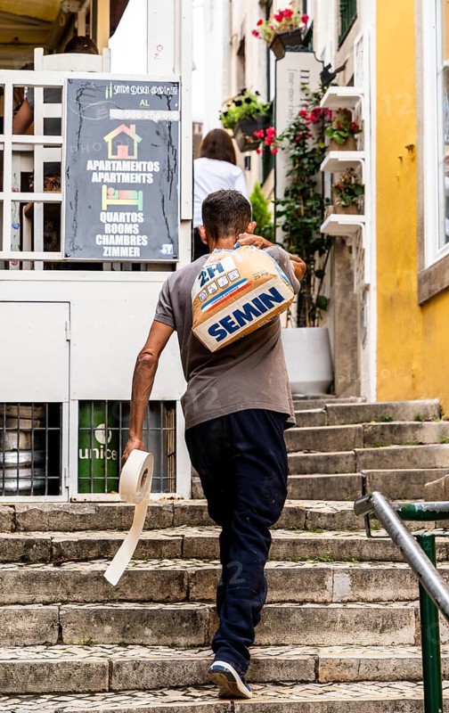 A craftsman carries a sack of cement, Sintra, Lisbon, Portugal