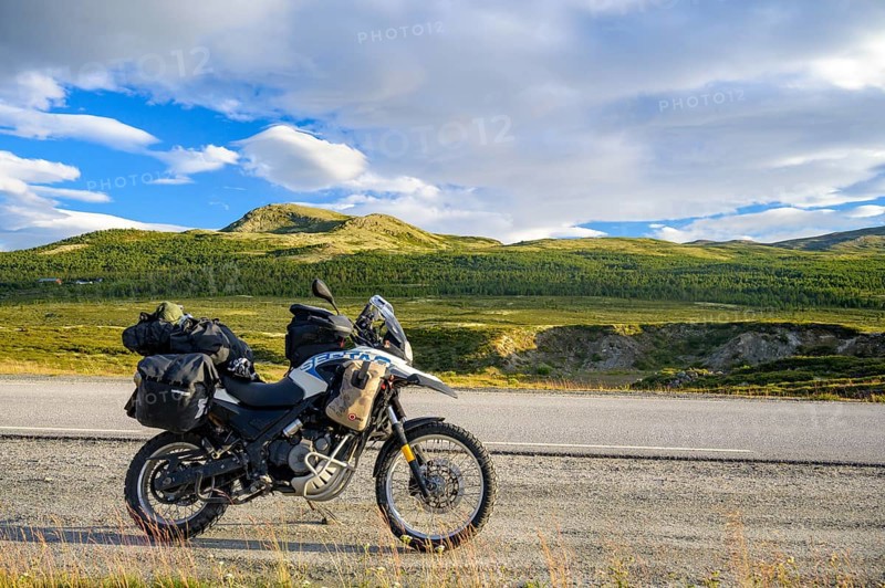 Dalholen, Innlandet, Norway, BMW G 650 GS Sertao enduro motorcycle along a road through green hills and wide skies on a journey