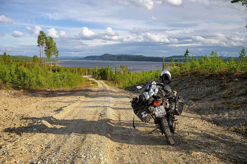 Lövdalen, Jämtland County, Sweden, BMW G 650 GS Sertao enduro motorcycle on a dirt road with views over vast countryside and lake