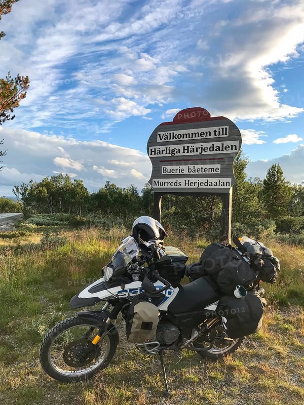 Funäsdalen, Jämtlands län, Sweden, BMW G 650 GS Sertao Enduro motorcycle is standing at a welcome sign Wonderful Härjedalen in a rural area with blue sky