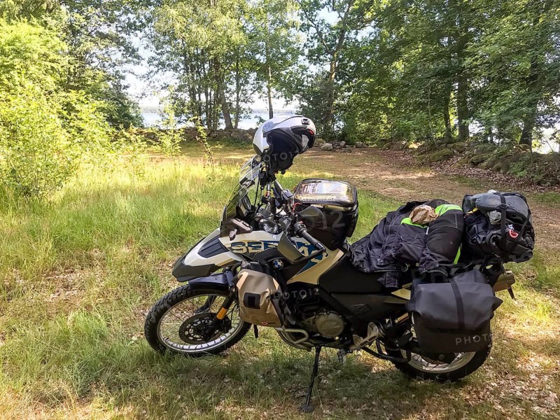 Kalvsvik, Kronobergs län, Sweden, BMW G 650 GS Sertao enduro motorcycle in the forest with packed luggage and helmet, surrounded by nature, Asnen National Park