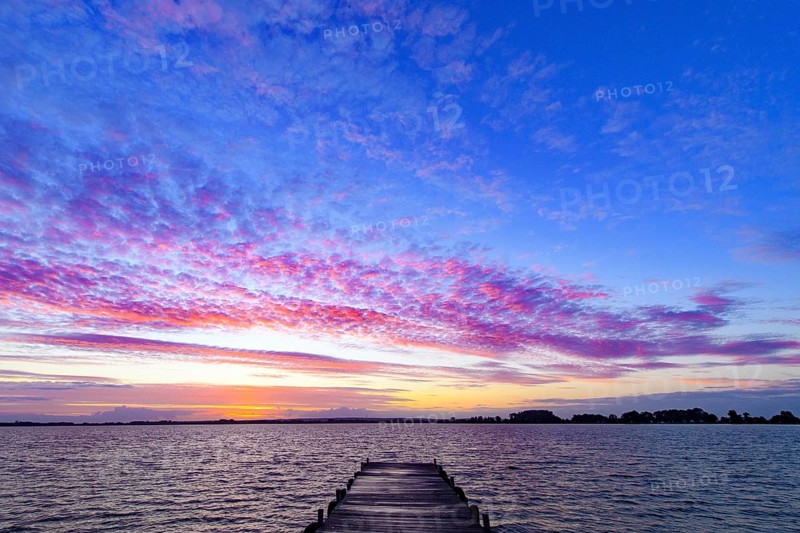 A footbridge leads into Lake Dümmer, above it a colorful sky at sunset, Dümmer nature park Park, Lembruch, Lower Saxony, Eutschland