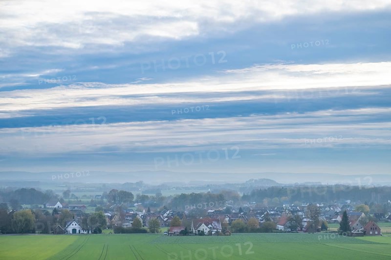 Extensive landscape with a village, fields, houses and cloudy sky in the morning, Föckinghausen-Westerhausen, Melle, Osnabrücker Land, Lower Saxony, Germany, quiet village landscape with wide fields and an overcast sky in autumn colors