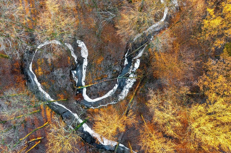 Frozen Määnder river loop of a stream in the Osnbrücker Land seen from the air, Melle, Lower Saxony, Germany