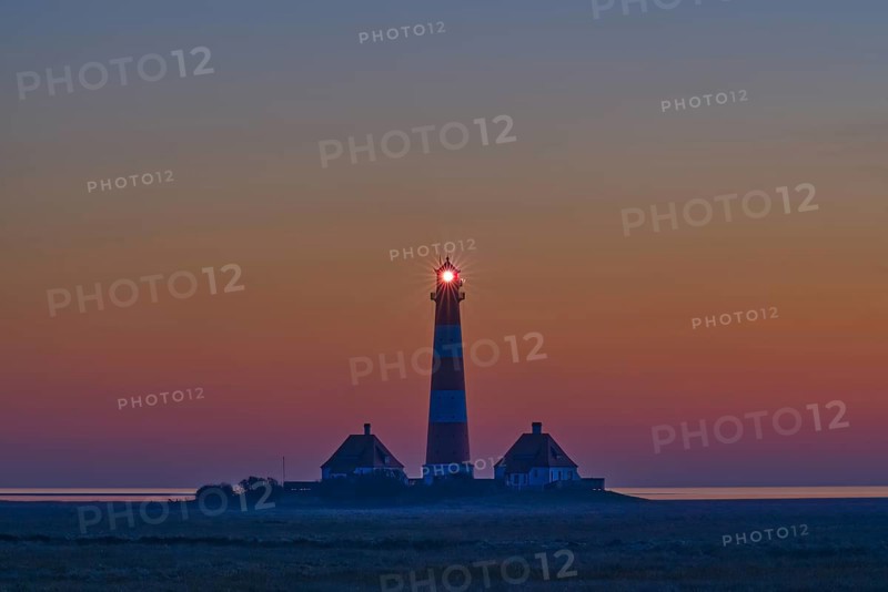 Silhouette of a lighthouse at sunset by the sea, calm and peaceful atmosphere